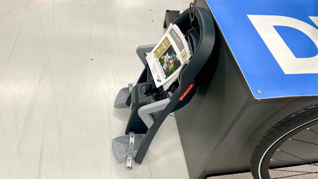 Kindersitz-Fahrrad-vorne-Test: ein Kindersitz ist an einem Regal angelehnt.