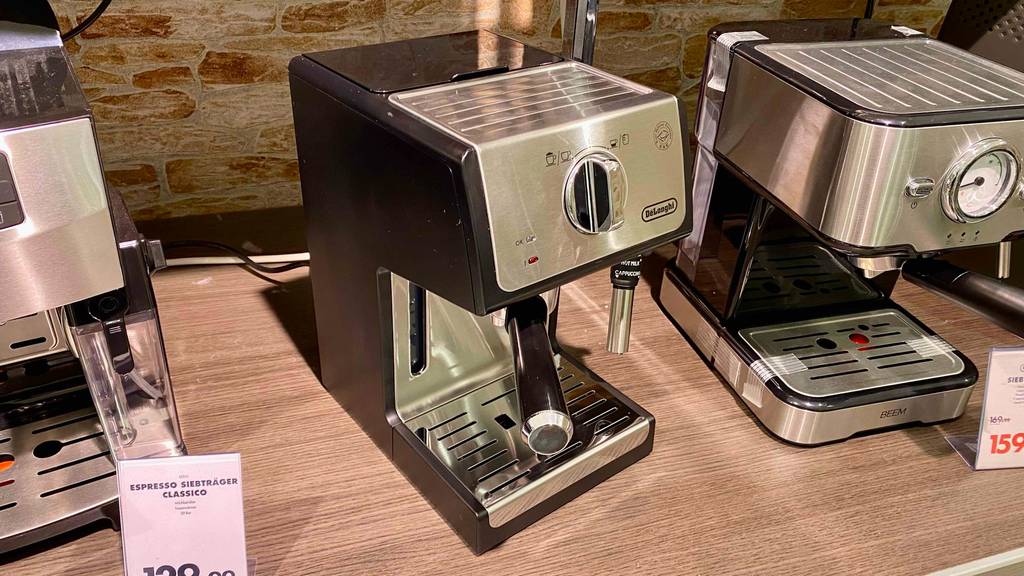 Eine getestete De’Longhi Siebträger-Maschine von vorn mit eingesetztem Siebträger steht neben anderen Siebträgermaschinen.