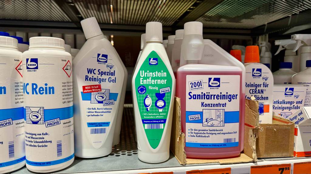 Der Urinsteinentferner im Test steht zwischen weiteren Reinigungsmitteln auf einem Verkaufsregal.