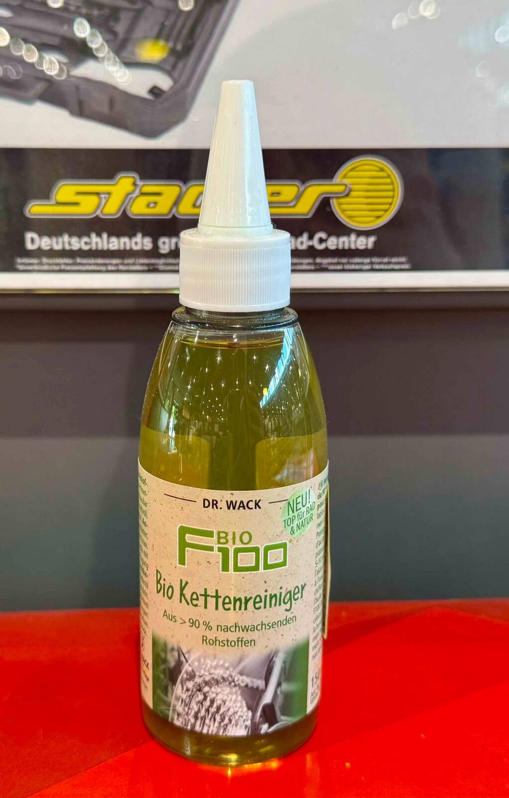 Kettenreiniger im Test: Die Dosierflasche mit dem Bio Kettenreiniger steht vor einem Verkaufsregal.