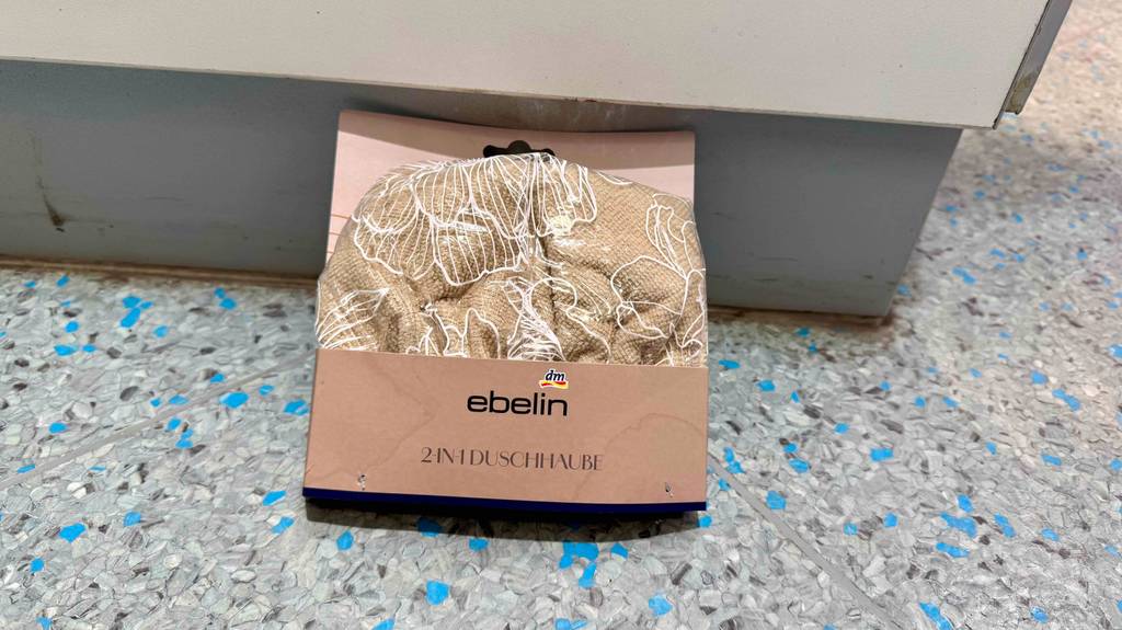 Eine getestete Duschhaube, die sich in der Verpackung befindet ist auf einem Boden platziert.