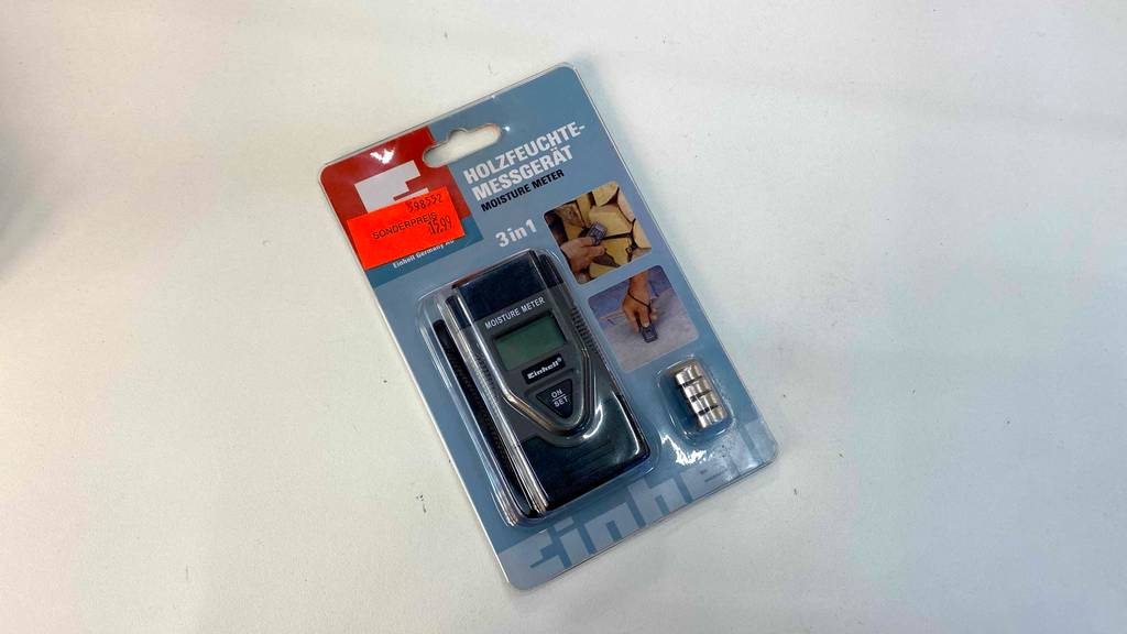 Holzfeuchtigkeitsmessgerät-Tesst: ein Holzfeuchtigkeitsmessgerät mit Batterien als Zubehör in der Verpackung.