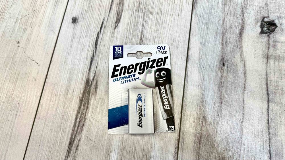 Die getestete 9V-Lithium-Batterie liegt in der Verpackung auf einer Fläche in Holzoptik.