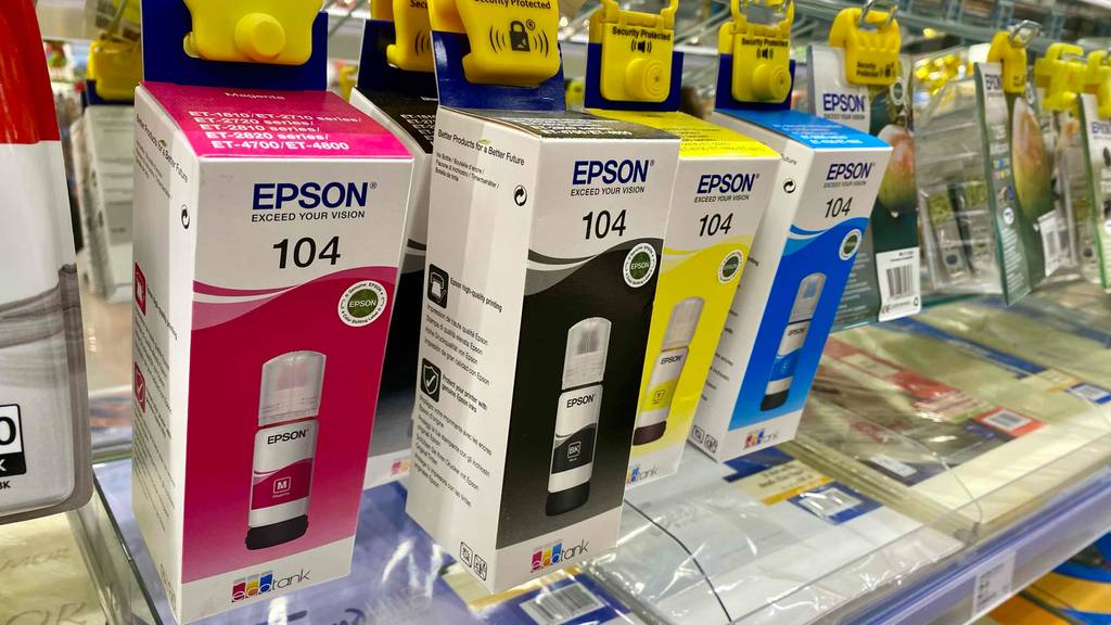 Mehrere getestete Epson-EcoTanks hängen nebeneinander im Regal.