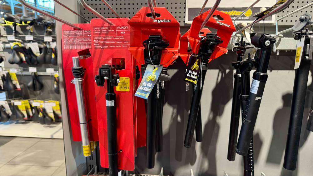 Mehrere getestete Ergotec-Sattelstützen hängen in einem Regal.
