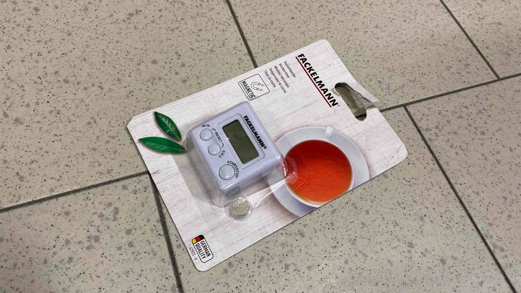 Im Test: Ein verpackter Kurzzeitwecker liegt auf einem Fließenboden.
