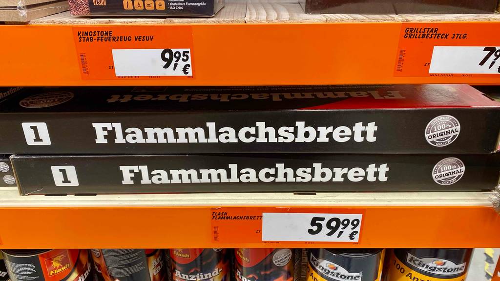 Im Test: Meherere Flammlachsbretter liegen übereinander in einem Regal.
