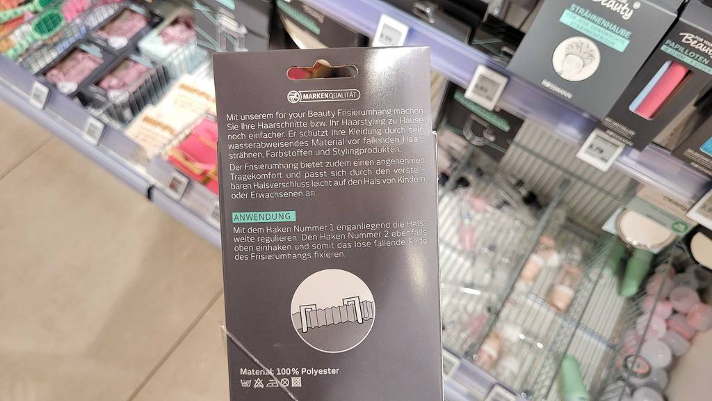 Rückseite der Verpackung des getesteten Friseurumhangs mit Anwendungshinweisen.