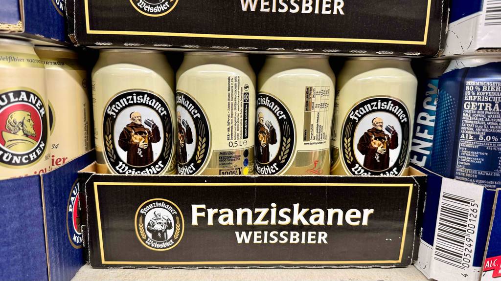 Mehrere Dosen deutsche Biere befinden sich in Kartons die übereinander gestapelt sind.