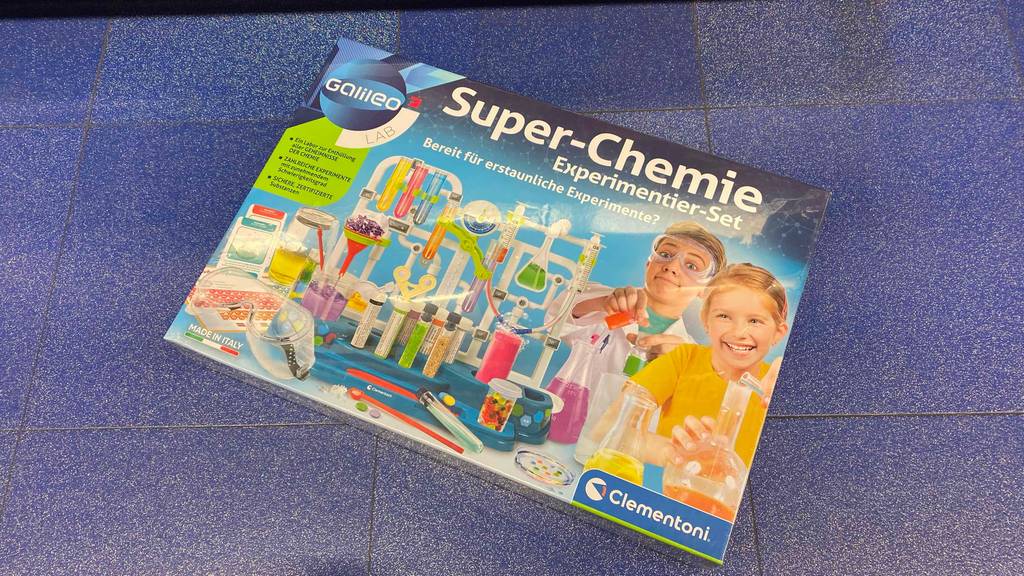 Im Test: Auf einem blauen Boden liegt quer ein Chemiebaukasten.