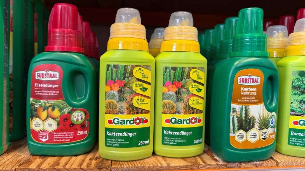 Mehrere getestete Kakteendünger stehen in einem Regal neben anderen Düngermittel.