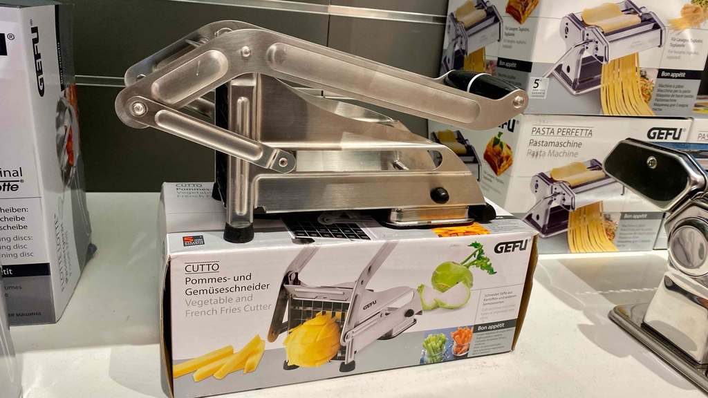 Ein getesteter Pommesschneider von der Seite ersichtlich, welcher auf seiner Verpackung platziert ist.