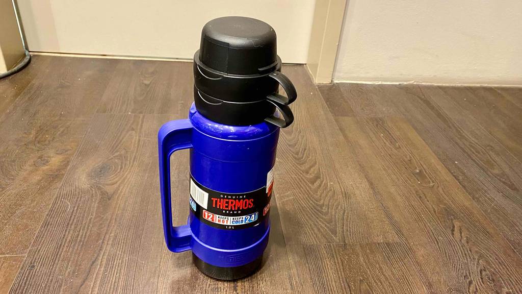Eine getestete Outdoor-Thermoskannen steht auf einem Boden in der Farbe Blau.
