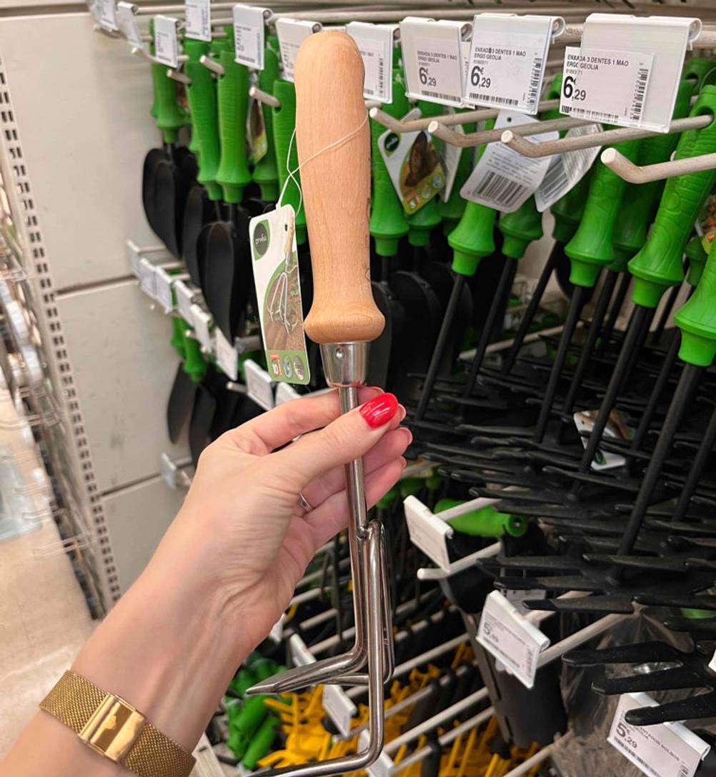 Harke getestet: Harke in der Hand vor einem Regal mit Holzgriff.