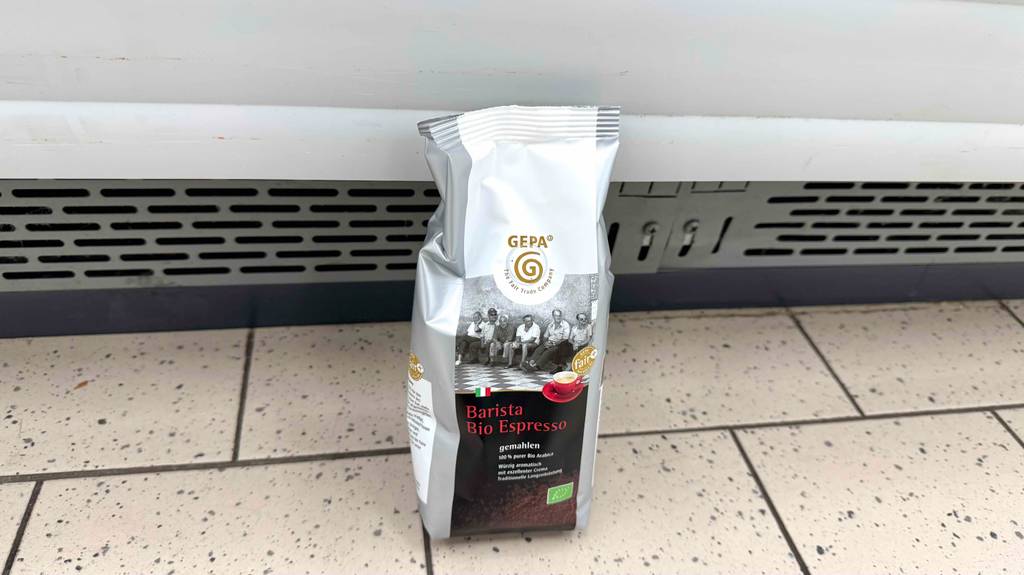 Getesteter Gepa-Kaffee steht vor einer Wand.