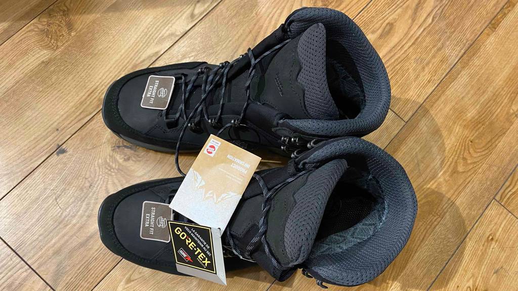 Gore-tex-Wanderschuhe-Herren im Test: Ein Paar schwarzer Wanderschuhe mit Schnürsenkeln stehend auf einem Boden.