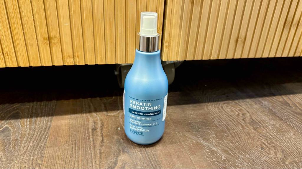 Die getestete Keratin-Spülung steht auf einem Boden.