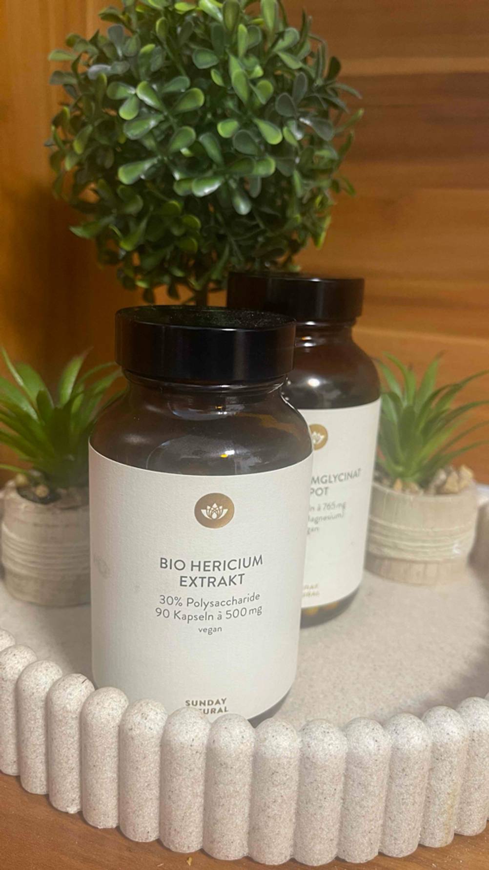 Zwei Packungen des getesteten Hericium-Extrakts stehen auf einem Deko-Tablett.