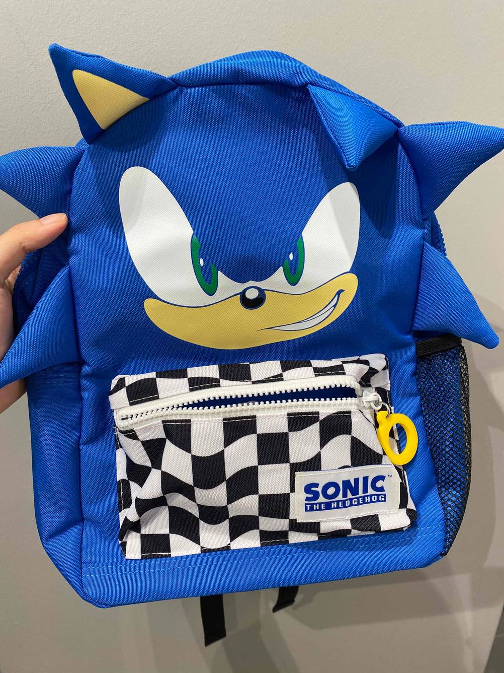 Kindergartenrucksack in der Hand.