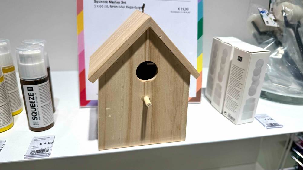 Das getestete Vogelhaus steht auf einer Ablagefläche, neben anderen Produkten.