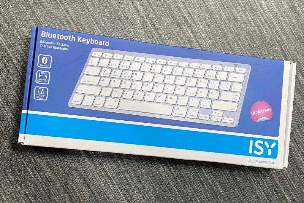 Im Test: Eine verpackte Bluetooth-Tastatur liegt vertikal auf einer dunklen Fläche.