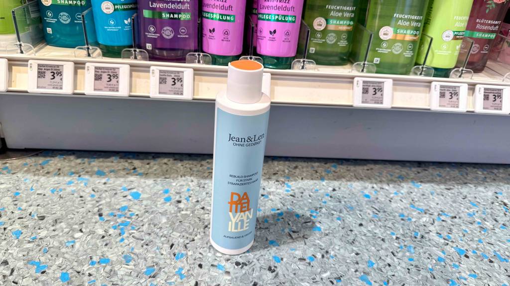 Jean-and-Len-Shampoo im Test: Eine Flasche des Shampoos steht vor einem Regal.