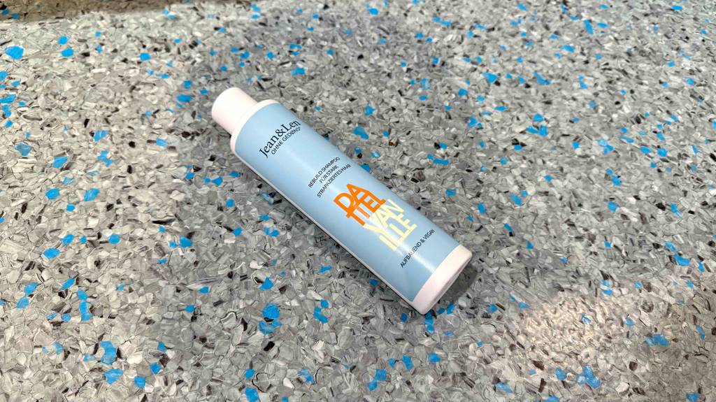 Test: Eine liegende Flasche Jean-and-Len-Shampoo, das für strapaziertes Haar geeignet ist.