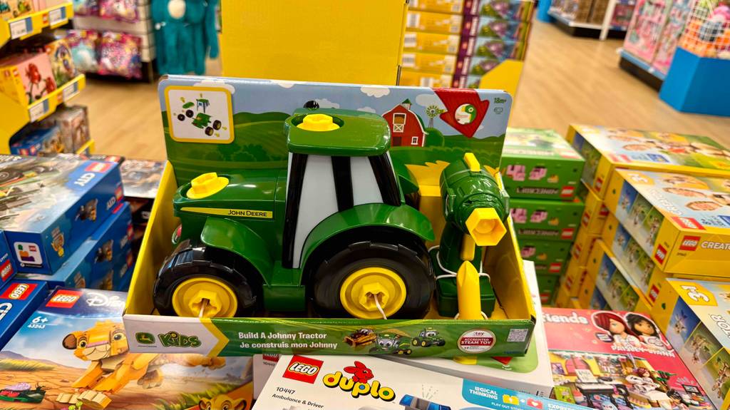Ein getesteter Spielzeugtraktor steht auf Lego-Verpackungen in einem Spieleuggeschäft.