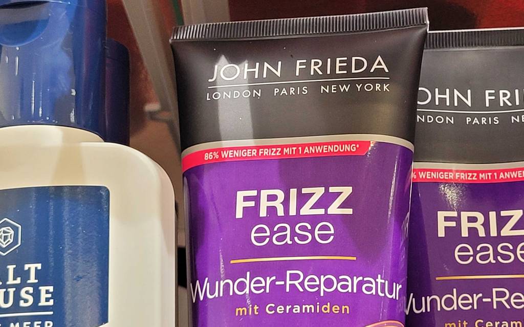 Oberer Teil der Tube des getesteten John-Frieda-Shampoos in Nahafunahme - mit dem Hinweis 86 % weniger Frizz mit 1 Anwendung.