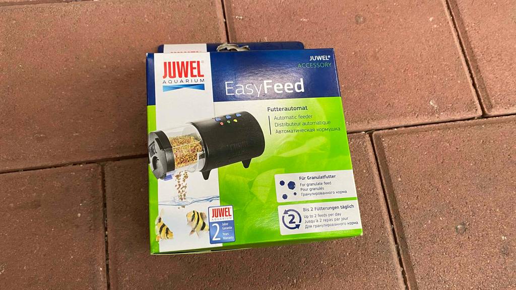Futterautomat-Aquarium im Test: Verpackung eines Futterautomats von Easy-Feed von vorn liegend auf einem Boden.