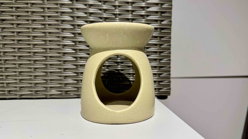 Duftlampen im Test: Ein beigefarbenes Modell steht vor einem Korbgeflecht.