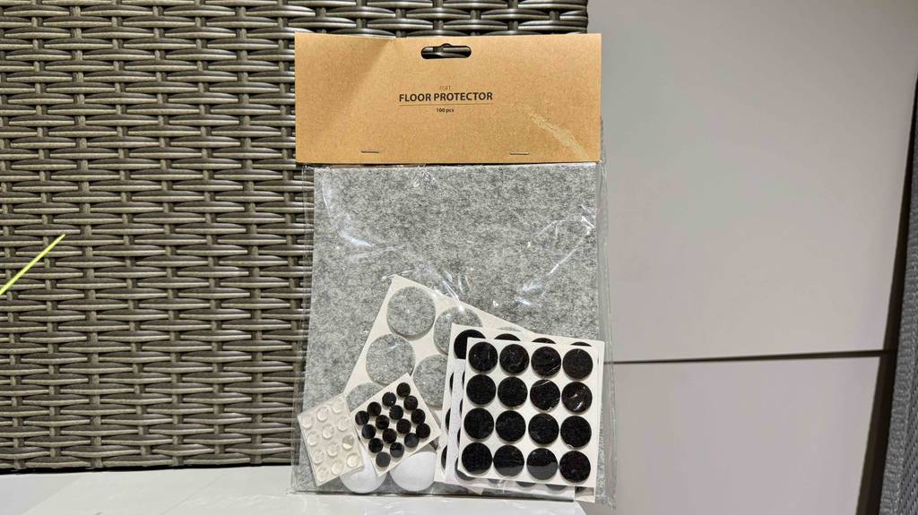 Eine Verpackung mit den getesteten Filzgleitern in verschiedenen Größen und Farben steht vor einem grauen Korbgeflecht.