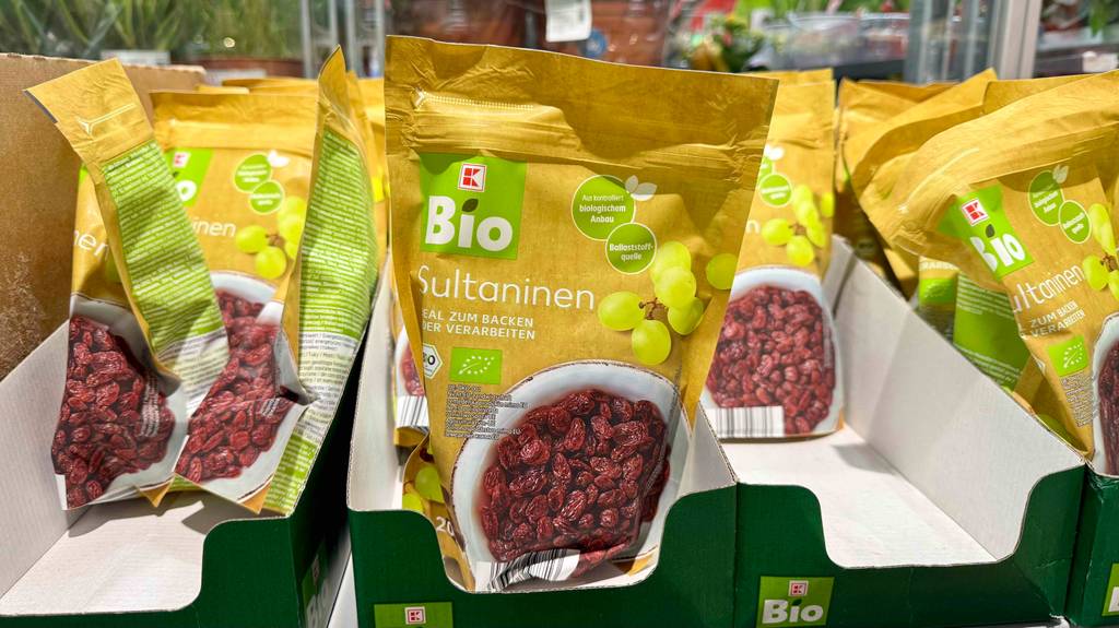 Mehrere getestete Packungen Sultaninen befinden sich in Kartons, die in einem Geschäft einsortiert sind.
