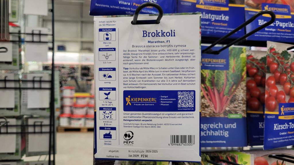 Verpacungsrückseite der getesteten Brokkoli-Samen im Fokus, welche in einem Regal hängt.