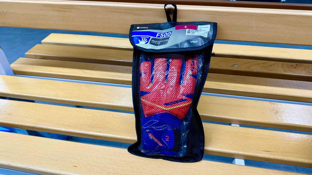 Die getesteten Kinder-Torwarthandschuhe, die sich in einer Tasche befinden ist auf einer Sitzbank platziert.