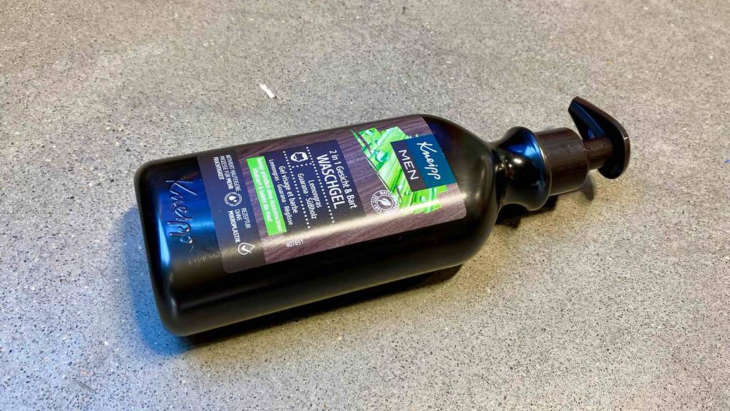 Bartwuchsmittel getestet: Auf einem Betonboden liegt eine Flasche horizontal.