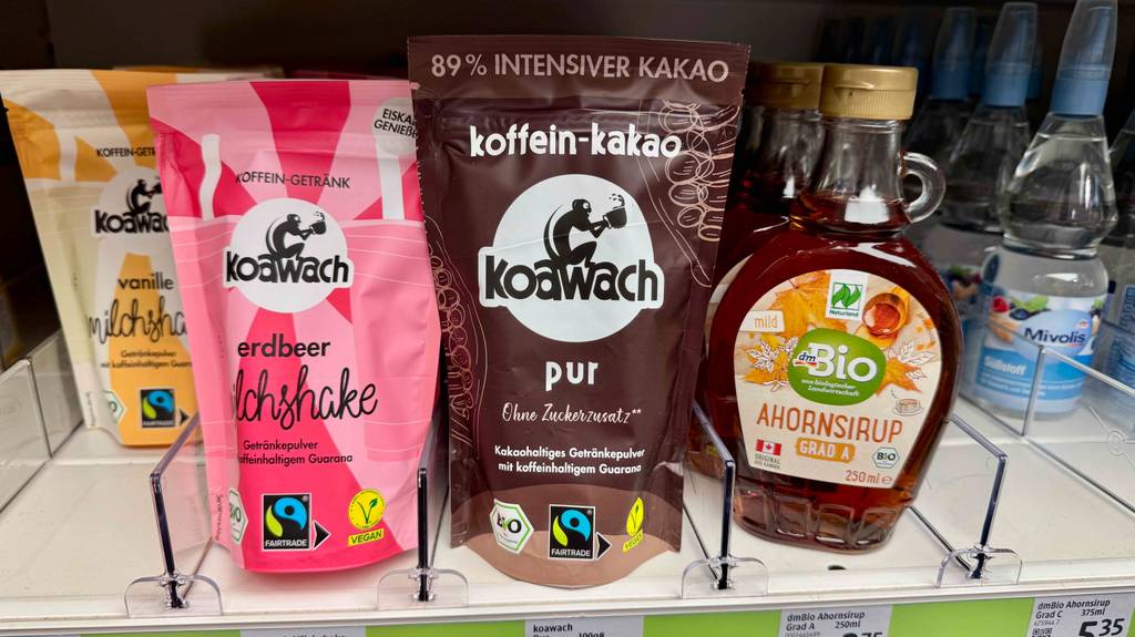 Das Kakaopulver ohne Zucker im Test steht in seiner wiederverschließbaren braunen Kunststofftüte zwischen weiteren Fertigprodukten auf einem Verkaufsregal.