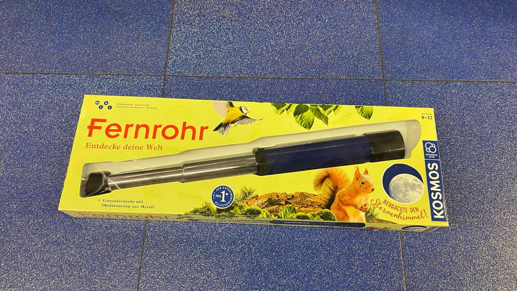 Fernrohr (Kinder) getestet: Ein verpacktes Fernrohr liegt auf einem blauen Boden.