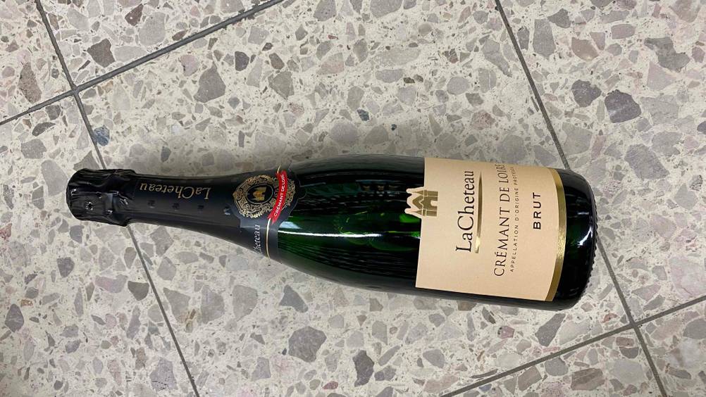 Crémant de Loire getestet: Eine Flasche liegt horizontal auf einem hellen Boden