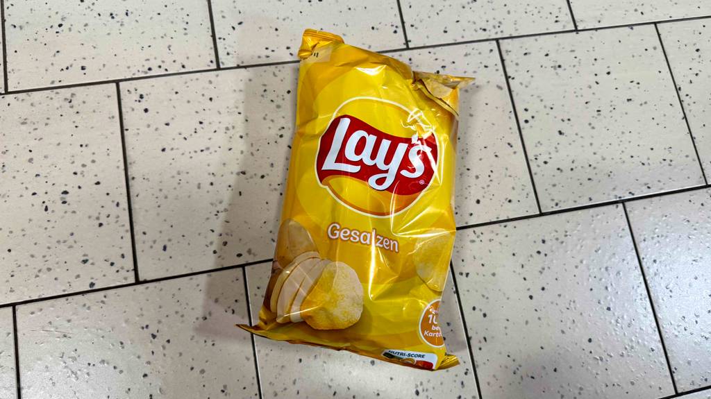 Eine Packung getestete Lay’s-Chips liegen auf einem Fliesenboden.