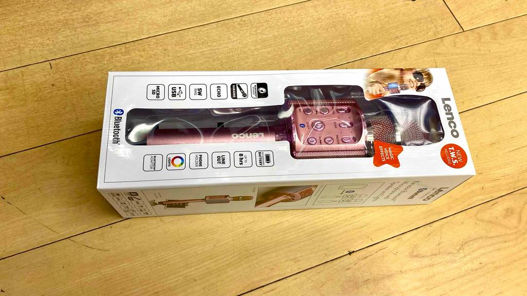 Im Test: Auf einem Holzboden liegt horizonal ein verpacktes Karaoke-Mikrofon.