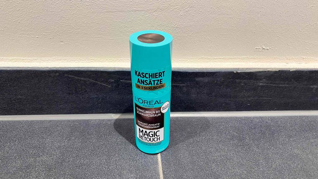 Ansatzspray getestet: Ansatzspray Magic Retouch für dunkelbraunes bis schwarzbraunes Haar stehend auf einem Boden.