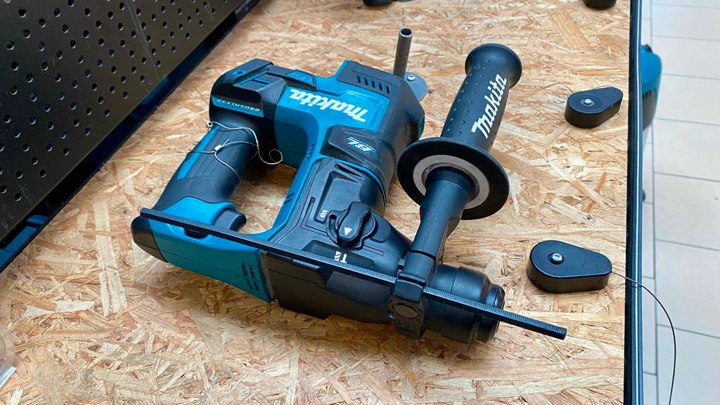 Makita-Akku-Bohrhammer im Test: Makita-Akku-Bohrhammer liegt seitlich auf einem Holztisch.