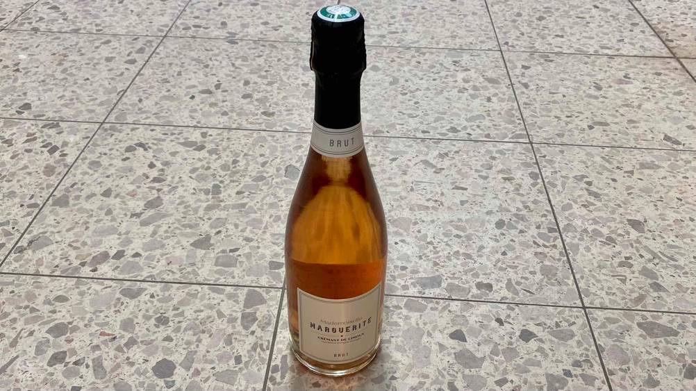 Im Test: Eine Flasche Crémant steht auf einem hellem Fließenboden