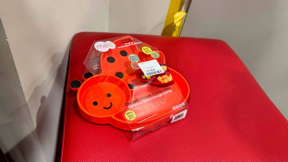 Ein getestetes Kindergeschirr aus Silikon in der Farbe Rot liegt auf einem roten Hocker.