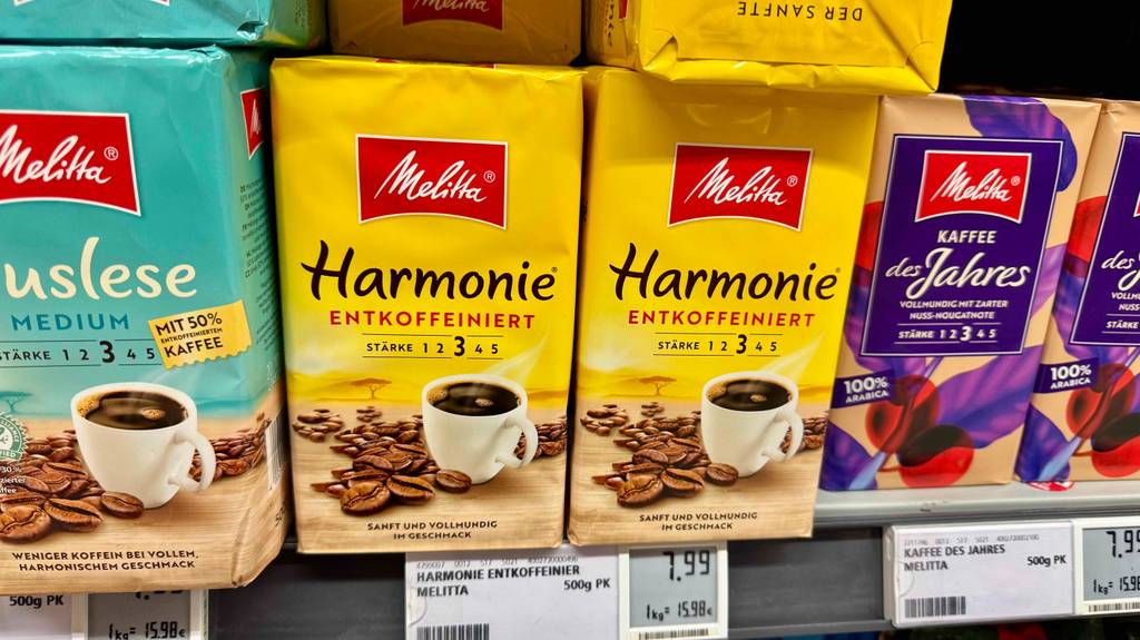 Mehrere Packungen der getesteten Melitta-Kaffeebohnen befinden sich in einem Regal neben anderen Kaffeebohnen.