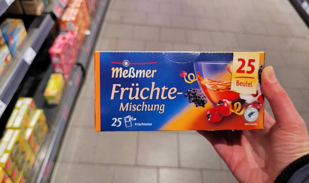 Eine Packung des getesteten Meßmer-Früchtetees wird in der Hand gehalten.