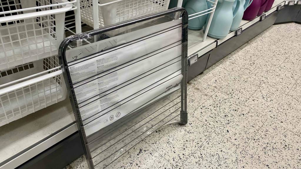 Ein getesteter Badewannentrockner mit der Rückseite ersichtlich ist an einem Regal angelehnt.