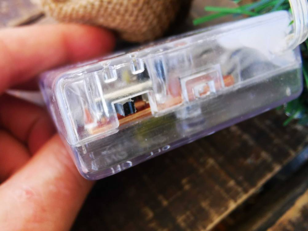 Der Ein- und Ausschalter des Batteriefachs des getesteten Mini-Weihnachtsbaums in Nahaufnahme.