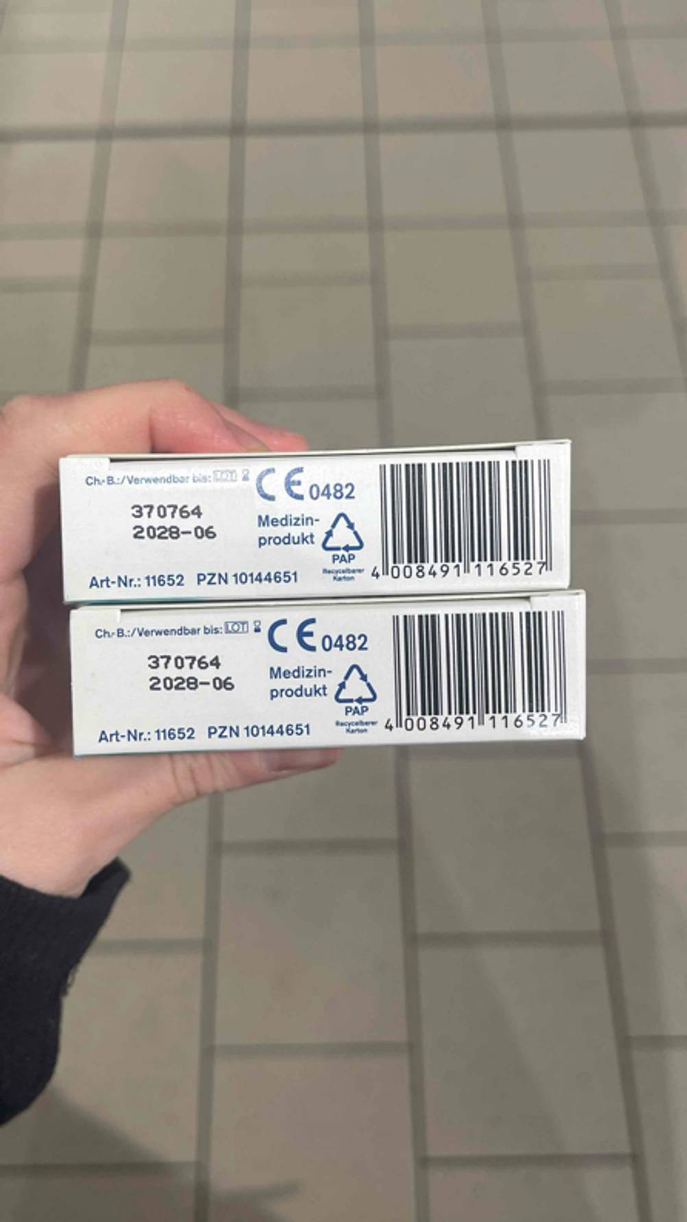 Zwei Verpackungen des getesteten Mittels gegen Sodbrennen werden in der Hand gehalten, während das Ablaufdatum darauf ersichtlich ist.